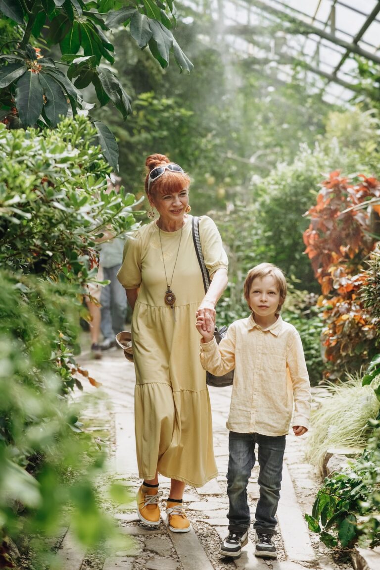 Young grandma walking with her little grandson in tropical botanical garden